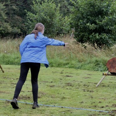 A Girl Guide projects a bow at an archery target