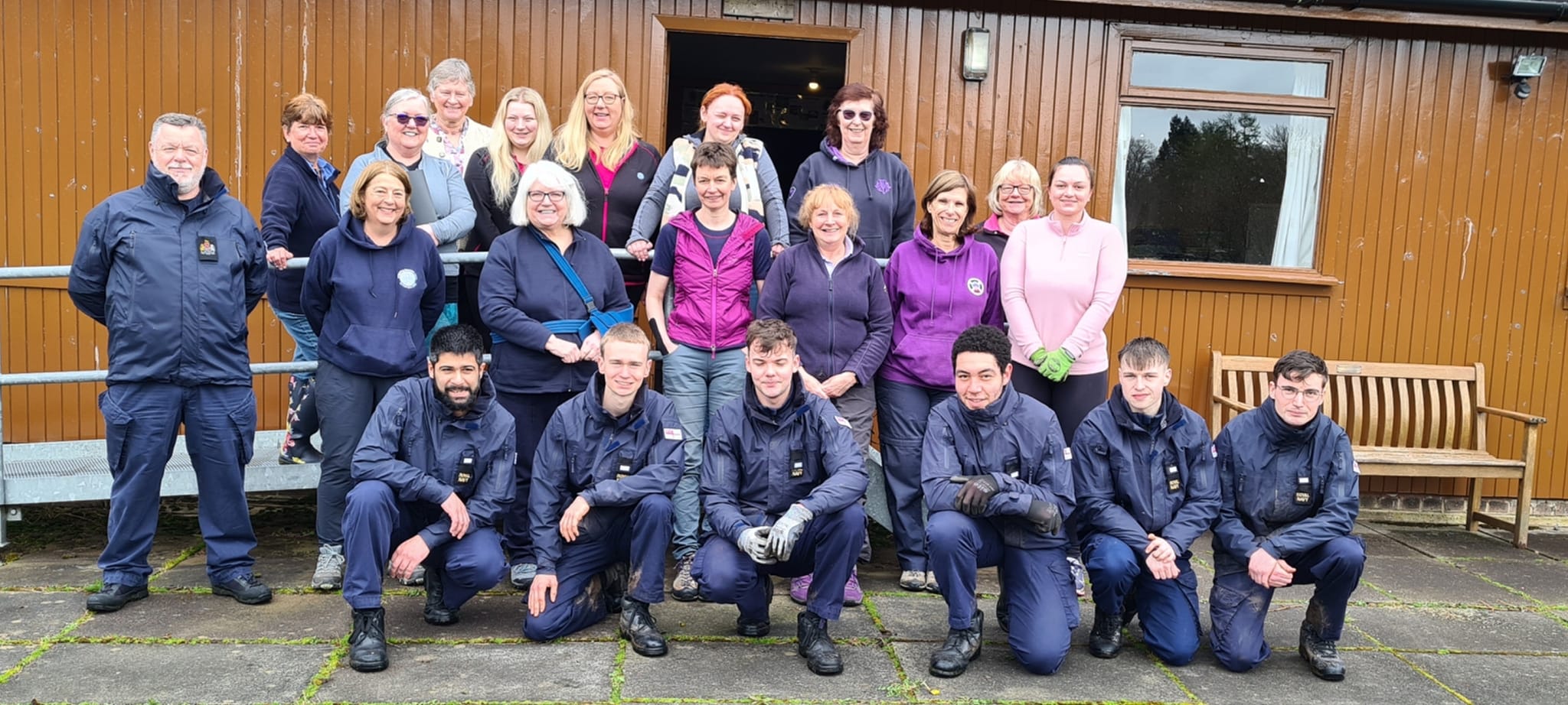 Girlguiding volunteers pose for a photo alongside the Navy