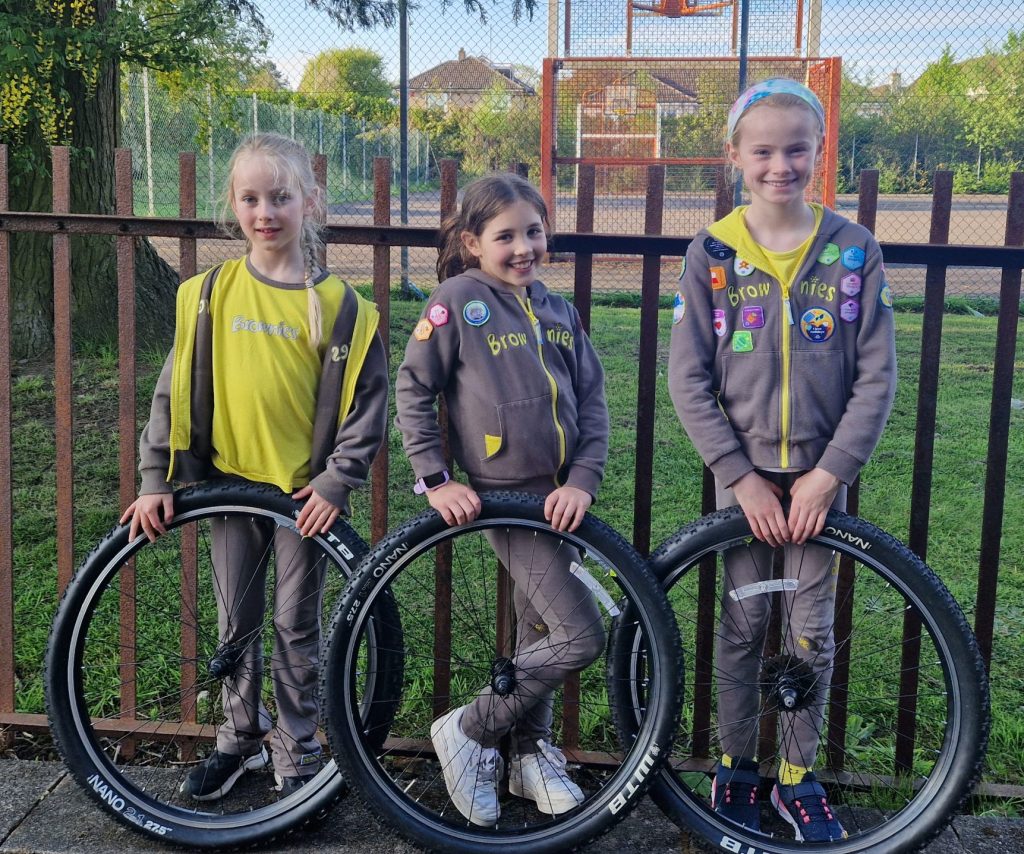 Brownies Addison, Lucia and Isabelle hold up three bike tyres