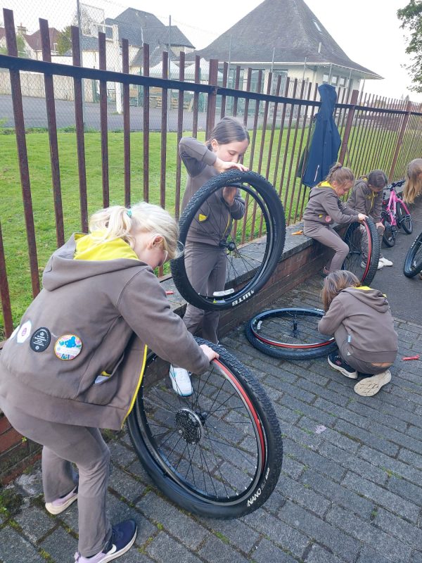 Anna and Katherine get to grips with replacing a bike tyre