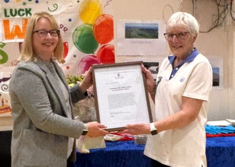 MSP Marie McNair and Elspeth Mitchell hold the framed motion to Parliament